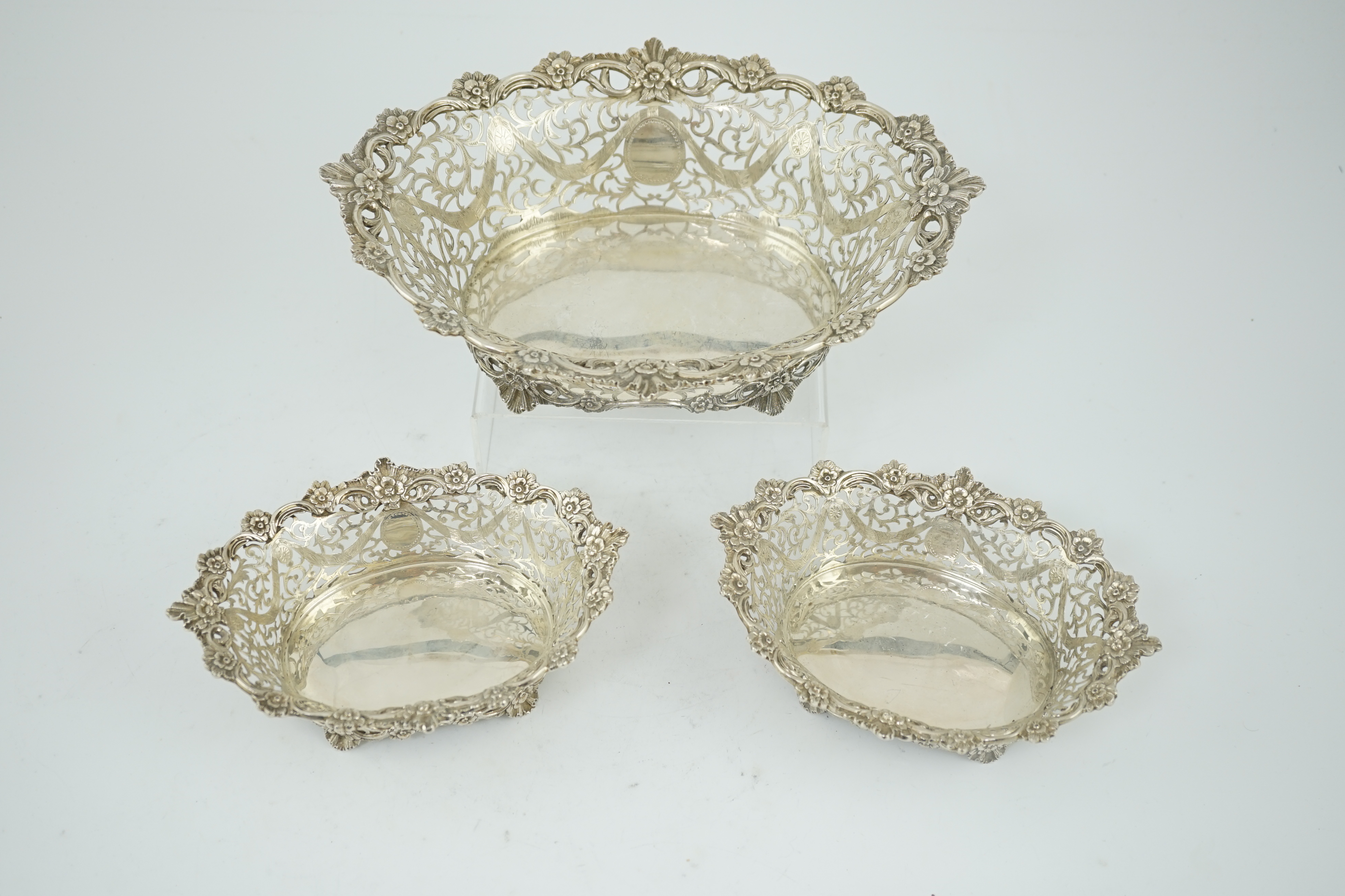 A graduated suite of three George V pierced silver oval bowls, by Charles Stuart Harris & Sons